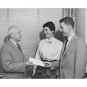 Two Silver Masque members give a donation check to President Ell