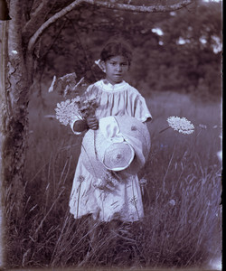 Girl holding a straw hat and wild flowers, Mashpee, Mass.