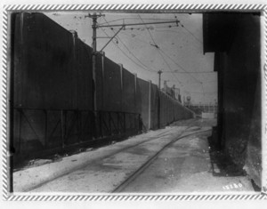 View looking down tracks with a metal guardrail on the left