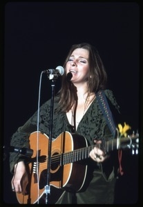 Judy Collins: in green velvet dress with guitar, performing on stage