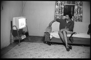 Mildred Loving, seated on couch, watching television