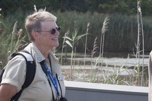 Jeannette Bragger (Mass Audubon Society volunteer) standing on a walkway, Wellfleet Bay Wildlife Sanctuary