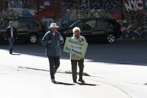 Older protesters joining the march opposing the war in Iraq, carrying a sign reading 'Another senior for peace'