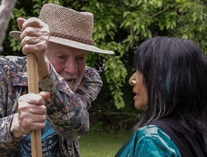 Pete Seeger: portrait leaning on a staff, talking with Buffy Sainte-Marie at the Clearwater Festival