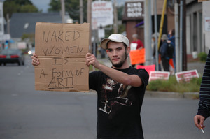 Protest against a pornographic video store in Northampton: counter-protester holding sign reading 'Naked women is a form of art'