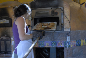 Hungry Ghost Bread: owner and baker Cheryl Maffei removing cookies from the oven