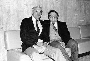 Two unidentified men sitting on a sofa