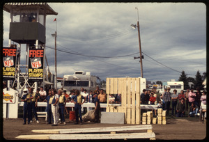 Spectators at a fairgrounds looking over car jump ramps