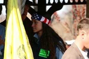 Young protester with American flag bandana on her head and sticker reading 'Socialism and liberation': rally and march against the Iraq War