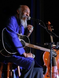 Richie Havens, with guitar, at the microphone on stage at the Clearwater Festival