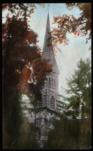 Stone church steeple surrounded by trees
