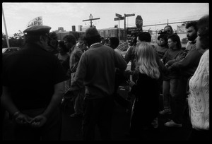 Escorts ushering a woman past police and pro-life protesters into the Providence Planned Parenthood clinic