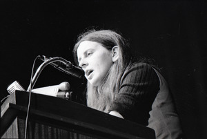 Bernadette Devlin McAliskey at the podium during a talk at Northeastern University