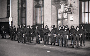 Police officers in riot gear waiting outside Cambridge Police station