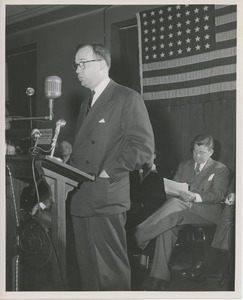 Unidentified man speaking on stage at Institute Day