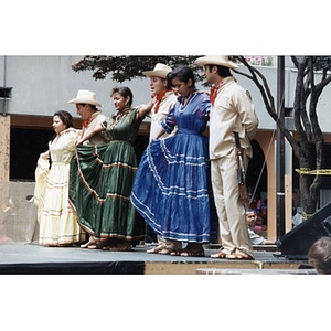 Six dancers in traditional costume line up on the outdoor stage at Festival Betances.