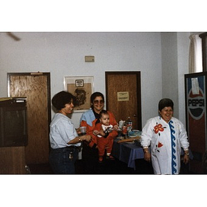 Clara Garcia holding a baby during an Inquilinos Boricuas en Acción staff meeting.