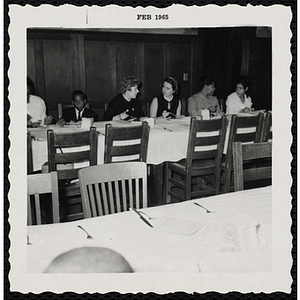A boy and several women eat and converse at a Boys' Club Inaugural Dinner