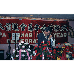 Man arranges a microphone before addressing a group gathered to celebrate the Lunar New Year with the Chinese Progressive Association