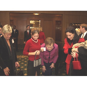 Four women looking at baby at the gala dinner honoring John Hatsopoulos