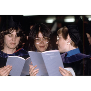 Three women graduates at the School of Law commencement ceremony