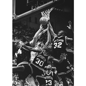 Several Huskies jump for the ball during the men's basketball NCAA playoffs