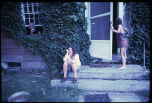 Three women by the entrance to a house