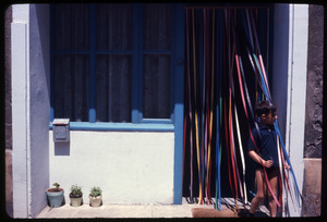 Boy walking through a doorway decked with colored streamers