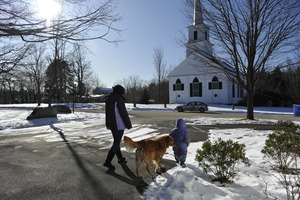 Mother, child, and golden retriever in the show in front of the New Salem Public Library, with 1794 Meeting House (First Congregational Church) in background