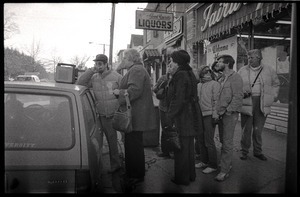 Crowd gathered about a radio perched on the hood of a car in Highland Falls, N.Y., listening to news of the arrival of the hostages from Iran