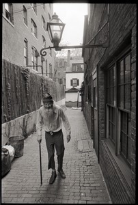 Prescott Townsend walking with a cane up a Beacon Hill alley
