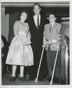 Unidentified man with two young clients at graduation exercises