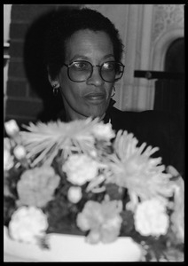 Johnnetta Cole seated behind a basket of flowers at the 10th anniversary celebrations for Women's Studies at UMass Amherst