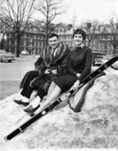 W. Hugh Morton sitting with Winter Carnival Queen Leslie C. Heye on snow mound, 1959