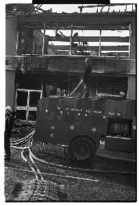 PIRA arson attack on Brown's Paint and Wallpaper Shop, Ballynahinch, Co. Down. Shots of firefighters, the British Army and others
