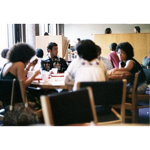 Hispanic people seated and eating in a dining area at a La Alianza retreat, [Aug.?] 1978.