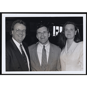 Two men and a woman posing at a St. Patrick's Day Luncheon