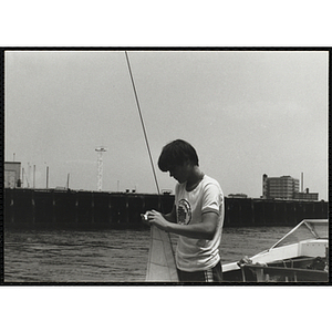 A Youth working with the sail from a sailboat