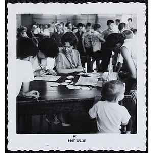 Three female staffers working at the registration table during a Boys' Club Little Sister Contest