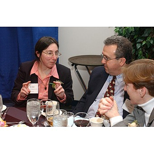 Three people converse at The National Council Dinner