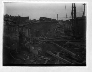 View of construction site, showing wood and steal beams and machinery