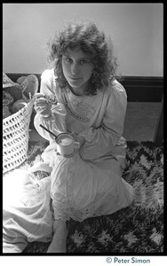 Cathy Brown (Usha), seated on the floor, eating