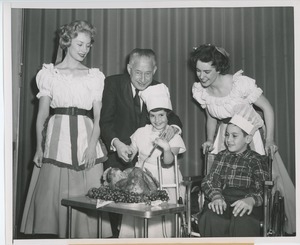 Abe Stark and two performers carving turkey with young clients