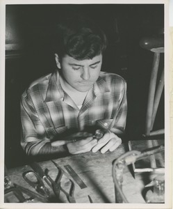 ICD trainee William DeMarshe shapes the gold presidential seal for the 1953 President's Trophy