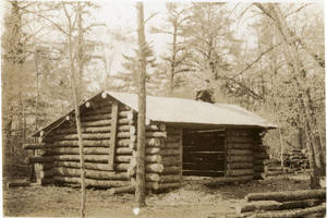 Log cabin with a man sitting on the roof