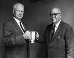 President Baxter holds cup with other man, 1959