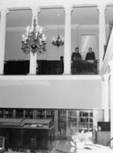 Two men examine books on the mezzanine of the Chapin Library gallery