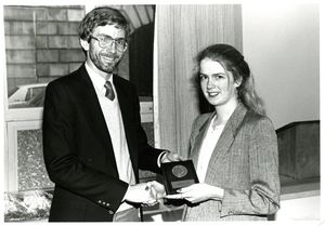 Suffolk University Professor David L. Robbins (CAS) presents an award to graduating senior Jessica Ladd