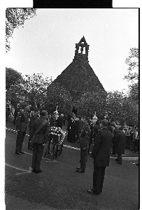 British Army funeral of UDR soldier murdered by the PIRA, at the Spa Loyalist "home-made arms" factory, Ballynahinch, Co. Down. British Army piper leading the funeral down a narrow country road. Various shots of mourners and hearse