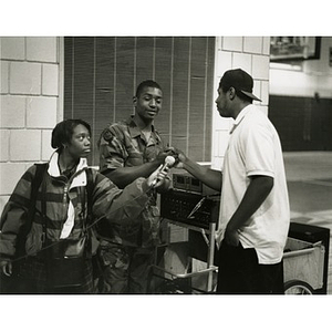 Teens interviewing a young man in army fatigues.